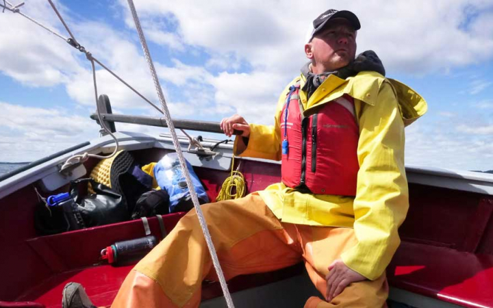 a veteran navigates a sailboat on an outward bound expedition